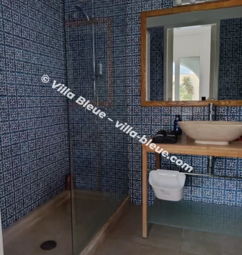 Italian shower in front of a mosaic wall
