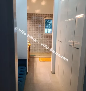 View of high cupboards and a fabric bench, overlooking the shower room
