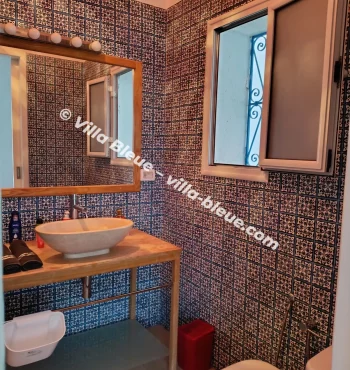 View of the sink and mirror in front of a mosaic wall