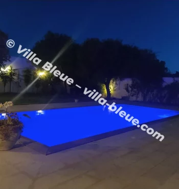 Swimming pool illuminated at night with blue light
